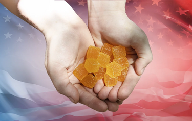 Hands holding Delta 9 THC gummies over the USA flag