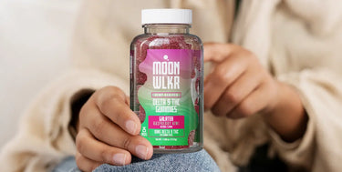 A person's hands holding a bottle of Moonwlkr Delta 9 THC Sativa strain gummies