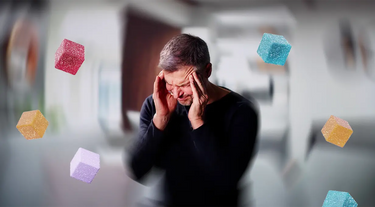 Man with headache surrounded by edibles