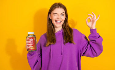 Woman holding mood enhancing gummies