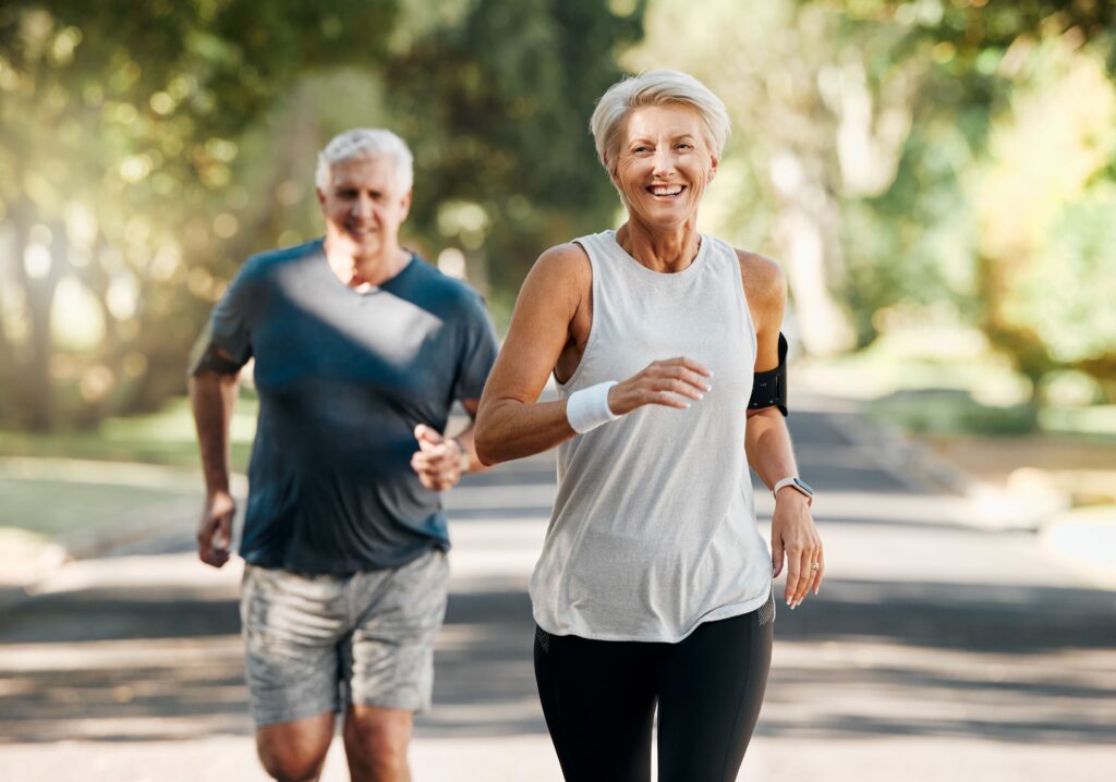 An older couple energized and happily running together