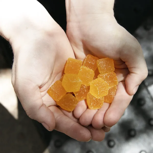 Hands holding a pile of sugar-coated sleep gummies for better rest and relaxation.