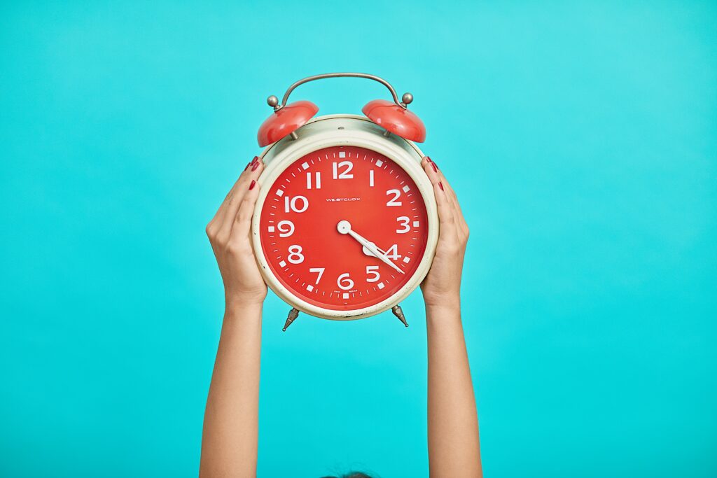 Person holding up a colorful clock