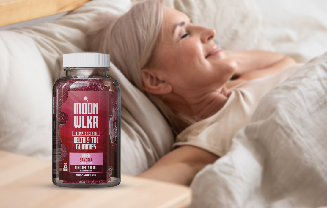 A woman happily resting in bed with a bottle of Delta 9 gummies