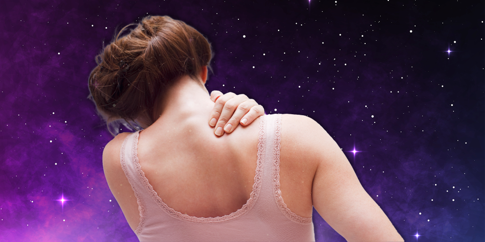 Woman with her back turned holding her neck in pain