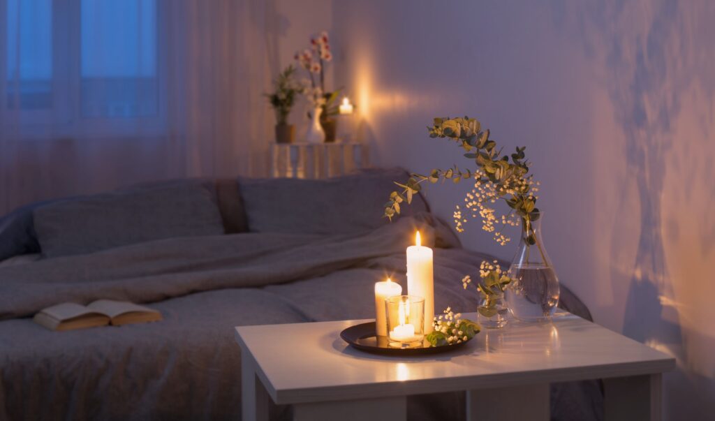 Peaceful bedroom environment with plants, lit candles, and a book to read
