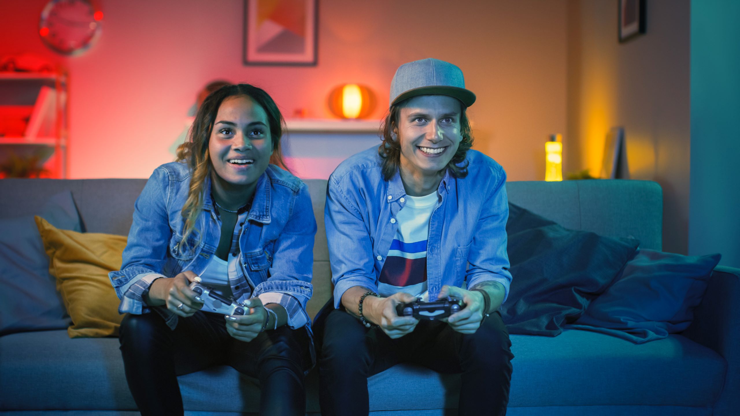 Two friends on a couch playing video games together