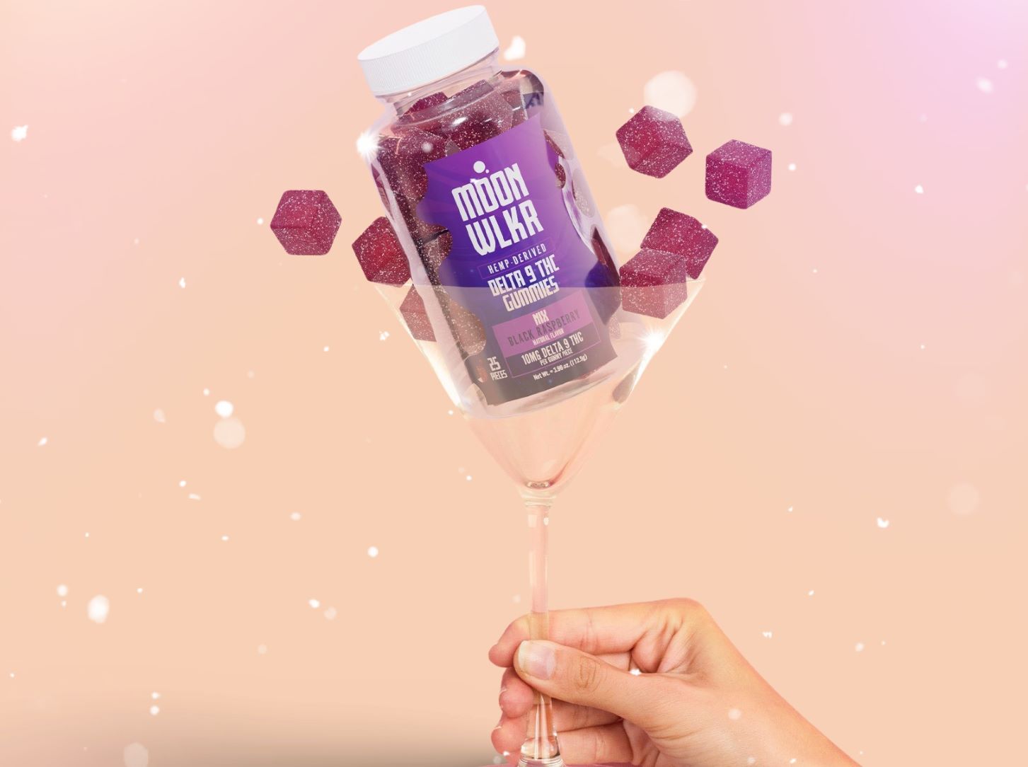 Hand holding up a Bottle of Delta-9 Gummies inside of a martini glass