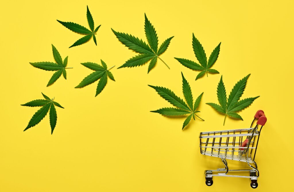 Cannabis leaves floating into a mini shopping cart