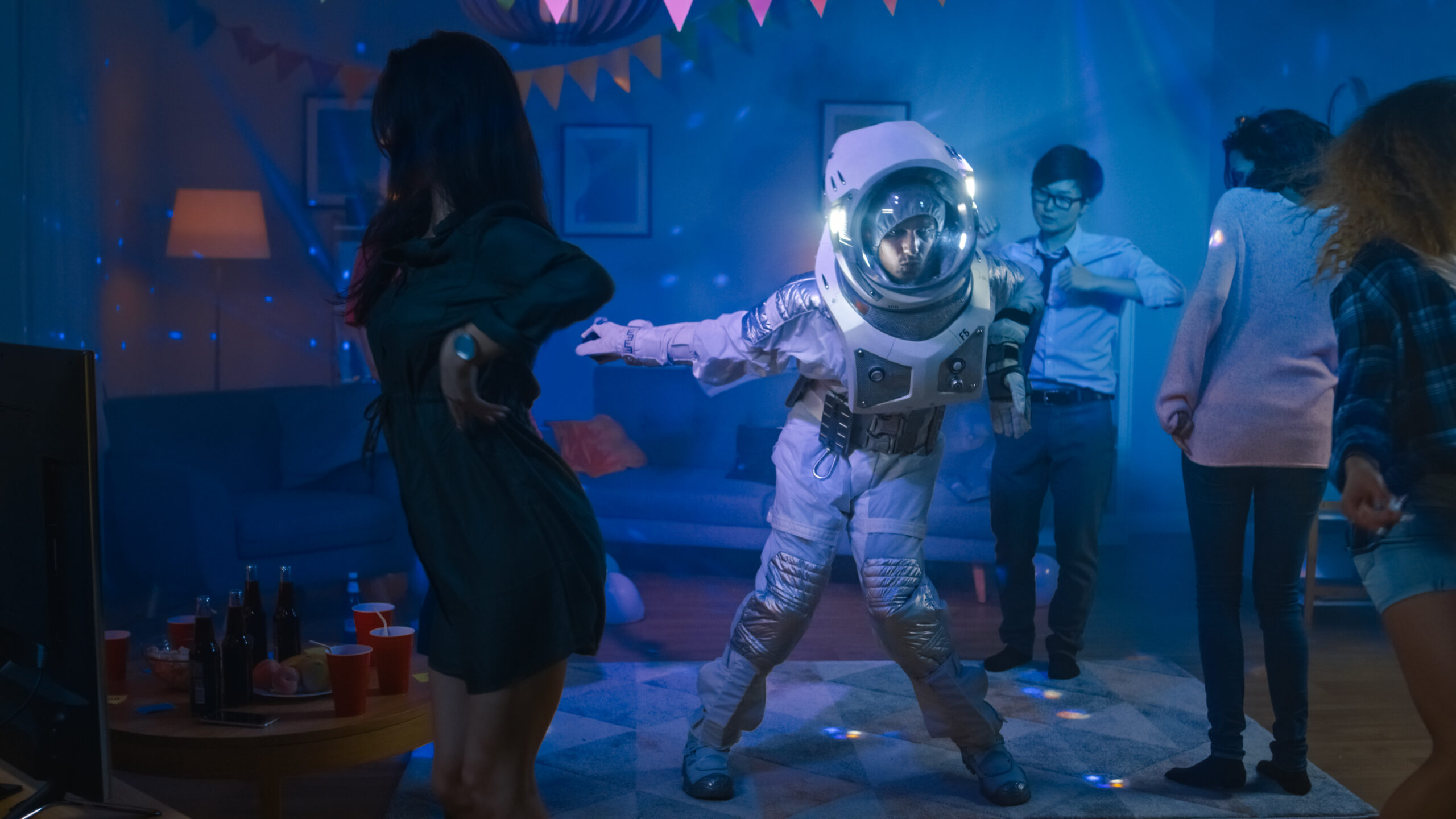 An astronaut dancing at a party with friends